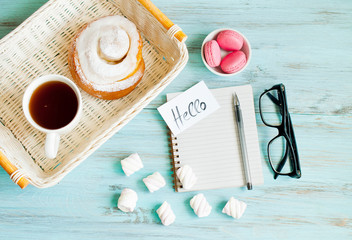 Notepad, glasses and a cup of coffee with a donut, morning concept