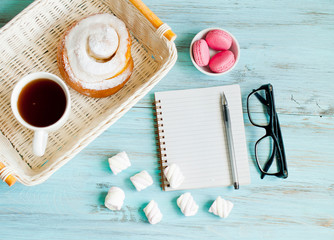 Notepad, glasses and a cup of coffee with a donut, morning concept