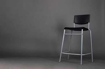 Black metal chair isolated on gray background with copy space in the studio.