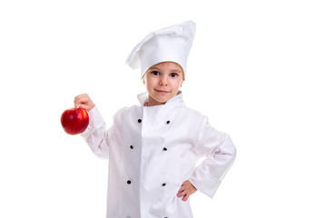 Serious chef girl in a cap cook uniform, holding with one hand on the red apple tail. Another hand is on the waist. Human emotions, facial expression feeling, attitude