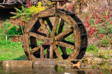 Working watermill wheel with falling water in the village © Oleksandr