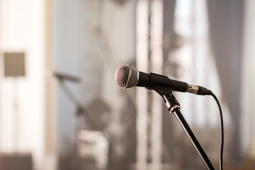 A microphone on stage in a concert hall or american bar (restaurant) during a show.