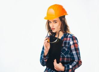 Beautiful business woman in a helmet and documents in her hands looks at camera. Pretty sexy lady with protective helmet holding glasses and black folder over the light background.