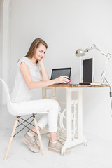 Young business woman working at home and draws on the tablet. Creative Scandinavian style workspace