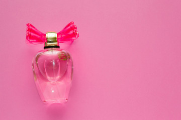 Glass bottle of pink adorable odor for women on pink background.