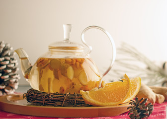 Delicious tea with ginger, orange and sea buckthorn in a transparent teapot