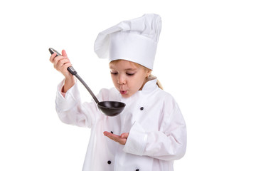 Girl chef white uniform isolated on white background. Holding black ladle and blowing to it. Looking at the ladle. Landscape image