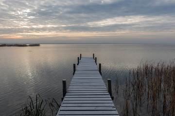 Sonnenaufgang am See und Steg mit Raureif