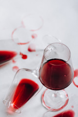 Glasses of spilled red  wine  on white  background,  copy space.  Wine degustation concept