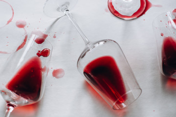 Glasses of spilled red  wine  on white  background,  copy space.  Wine degustation concept