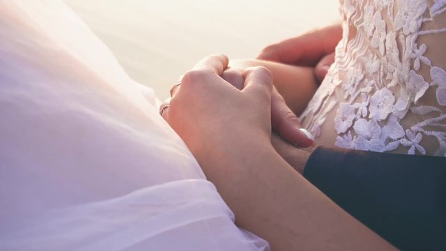 young couple in love near the river at sunset on the pier, the bride in a wedding dress with the groom