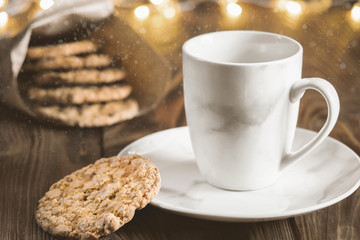 Tea mug on a plate with homemade oatmeal cookies