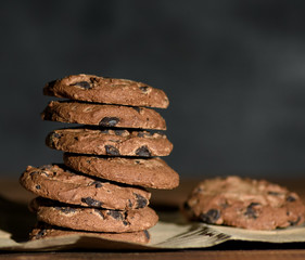 stack of round chocolate chip cookies on brown paper