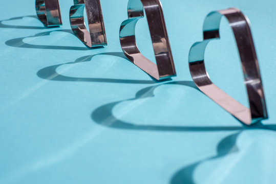 Shadows of metal shapes in the form of a heart on blue