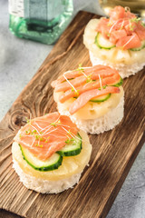 Bruschetta toast of white bread with slices of pineapple cucumber fish salmon fresh green sprouts