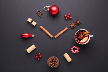 A clock in the form of spice for mulled wine. Cinnamon, anise stars, cranberries, brown sugar. Concept, creative work.