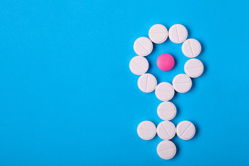 Gender symbol of woman from pills on blue background top view with copy space place for text, concept about female health.