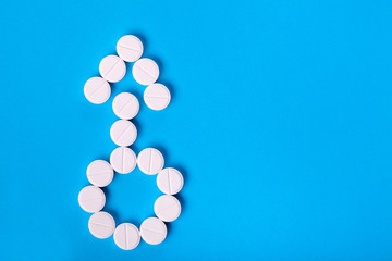 Symbol of masculinity from pills on blue background top view with place for text, male erection symbol.