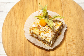 Layered cake with cream Napoleon vanilla slice on wooden background, top view