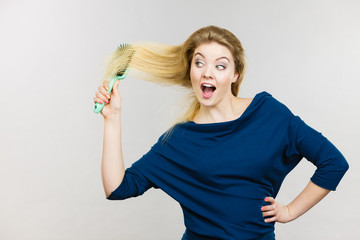 Woman brushing her long hair with brush