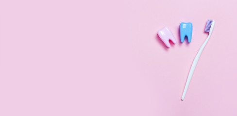 Toothbrush and big tooth on blue and pink background. Teeth care minimalism concept.