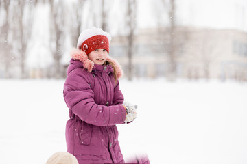 Cute little girl walking in snow park, happy childhood