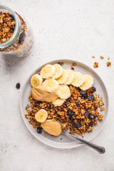 Baked granola with raisins, banana and peanut butter, top voew, copy space.