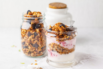 Obraz na płótnie Canvas Baked granola, jam and yogurt healthy breakfast parfait in glass.