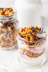 Baked granola, jam and yogurt healthy breakfast parfait in glass.
