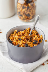 Baked granola with raisins in gray bowl.