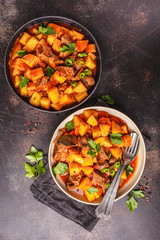 Spicy beef stewed with potatoes in tomato sauce, top view. Meat traditional goulash.