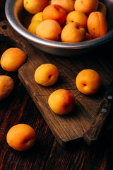 Mellow apricots with knife over cutting board