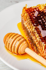 Honeycomb on plate with honey dipper