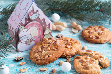 Christmas cookies with peanuts on spruce background and blue wooden table.
