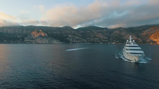 South of France sea, aerial view with large private luxury super yacht and chase boat underway.