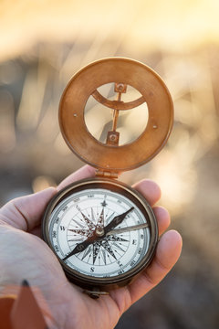A first-person view of a man's hand with retro compass.