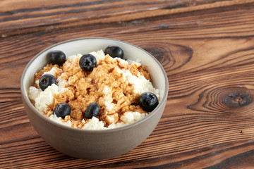 cottage cheese with blueberries on a dark wooden background