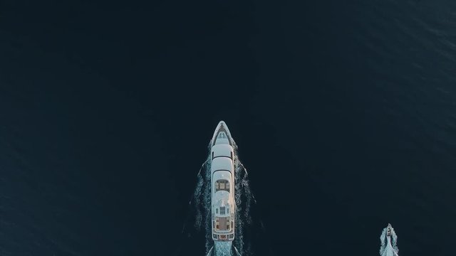 Top-down aerial view of a private luxury yacht and chase boat moving parallel to each other