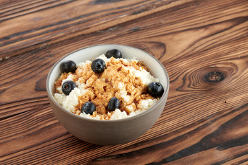 cottage cheese with blueberries on a dark wooden background