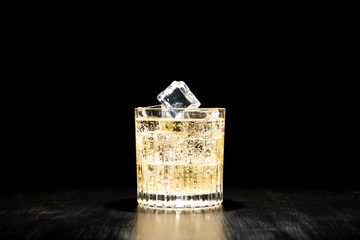 Fototapeta premium dark background whiskey ice glass ice hand photo moody pouring alcohol bourbon bartender bar hotel home
