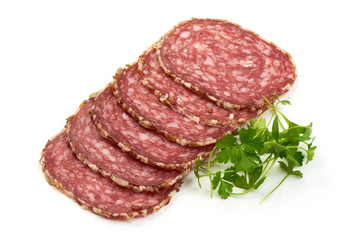 Dried Sliced Salami Sausage with parsley, isolated on white background. Close-up