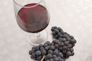 Cup of red wine and a cluster of grapes, horizontal photo
