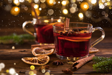 Christmas hot mulled wine with spices on wooden background.