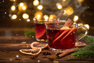 Christmas hot mulled wine with spices on wooden background.