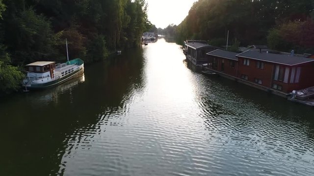 Low altitude aerial footage of houseboats on left side showing conventional ship and on right the typical dutch type of wooden living boats beautiful day just before sundown 4k high resolution