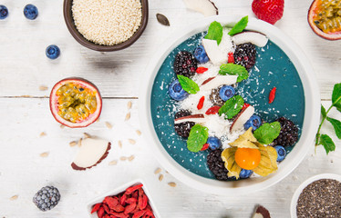 Smoothie bowl with fresh berries, nuts, seeds, fruit and vegetables.