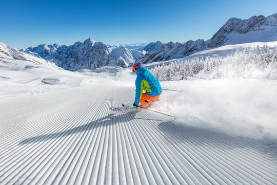 Skier skiing downhill in high mountains