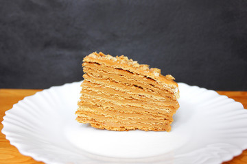 Piece of honey cake on black background