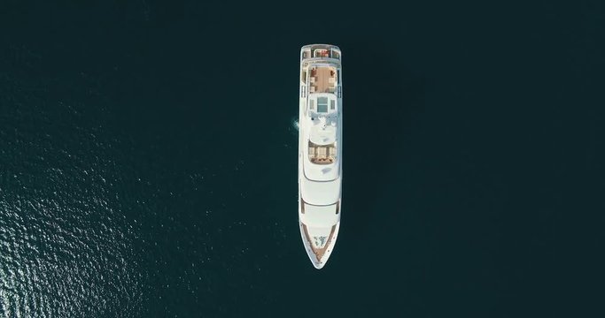 Top-down aerial view of large white yacht, camera movement up