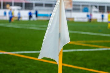 White corner flag close-up on the background of a football field. Soccer field.